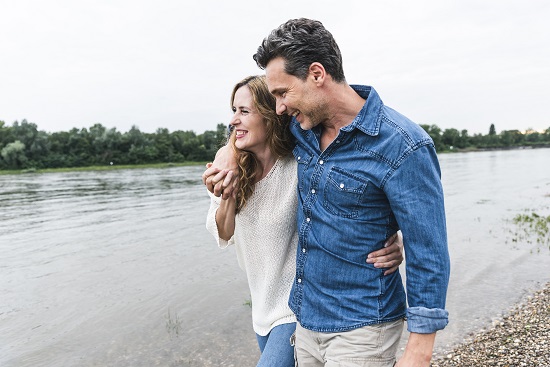 Couple walking alongside river