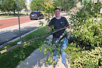 Here I am helping to clear overgrown tree limbs and debris from city sidewalk areas!