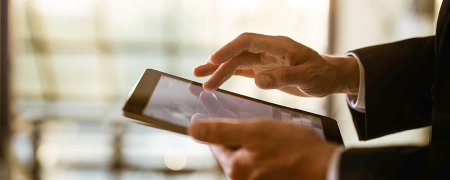 Businessman on his tablet, reviewing investments.