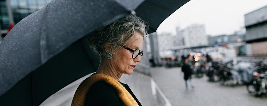 Woman under umbrella looking down.