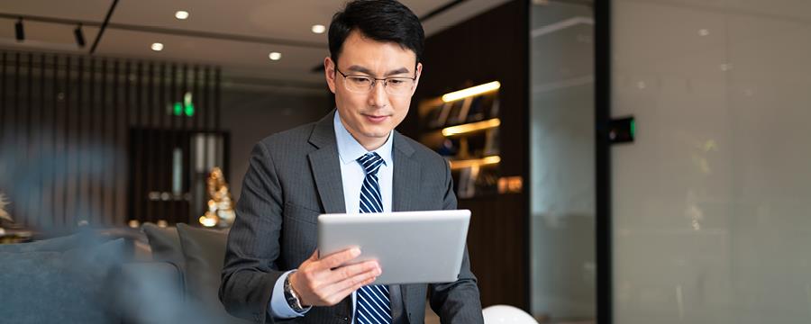 Portrait of confident businessman reviewing work on his tablet.
