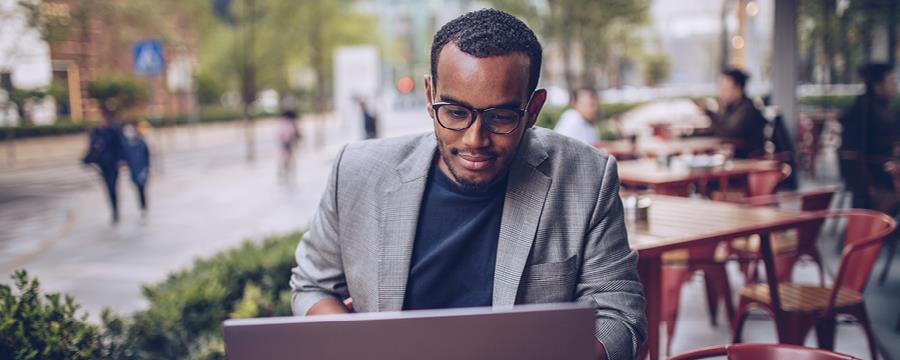 Smiling man reviewing his accounts at an open air cafe