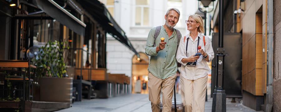 Mature couple enjoying a leisurely walk down a European city street.
