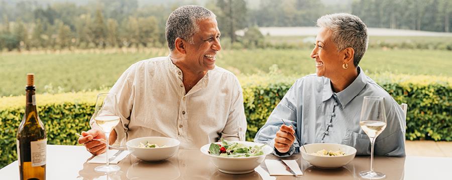 Mature couple eating lunch while on holiday at a vineyard.