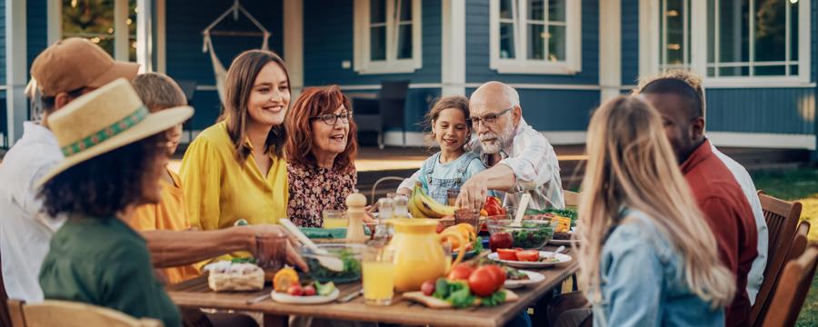 Multigen family sharing a meal outside.