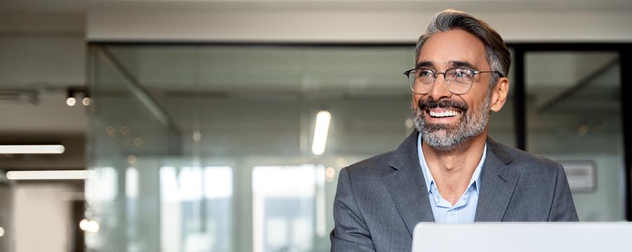 Portrait of a businessman using a laptop in his office.
