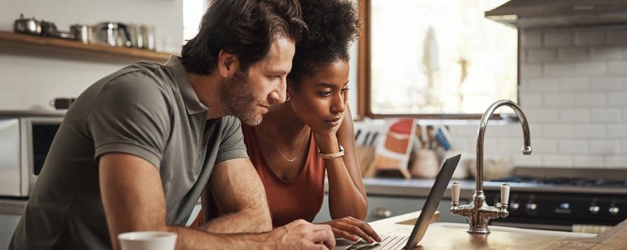 Couple reviewing tax documents on laptop.