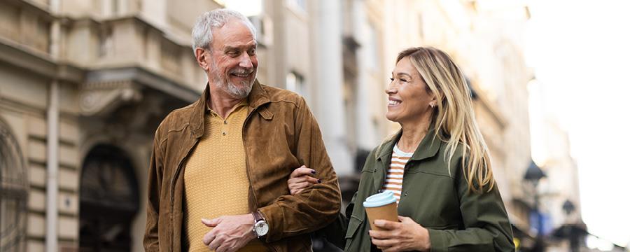 Cheerful retired couple taking a relaxing walk in the city.