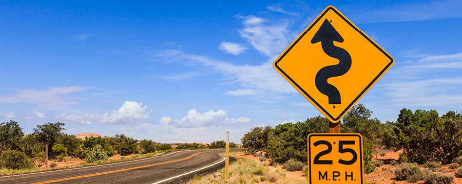 A winding road caution sign along a U.S. highway