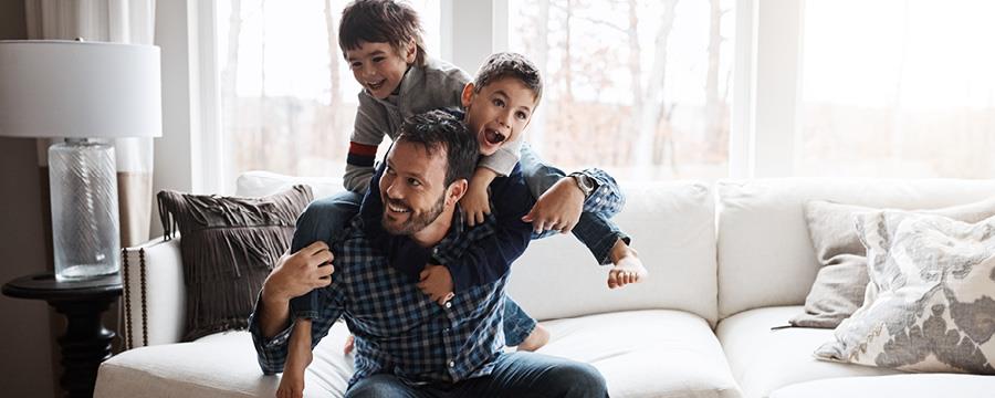 Father playing with his two sons in his living room