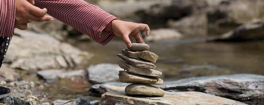 Woman stacking balancing rocks