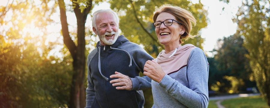 Cheerful, active couple jogging in the park