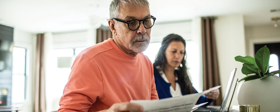 A person in glasses reading a newspaper