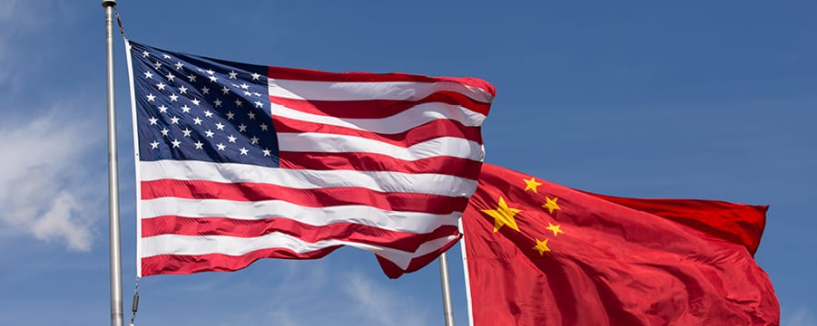 The U.S. flag and Chinese flag flying in the wind