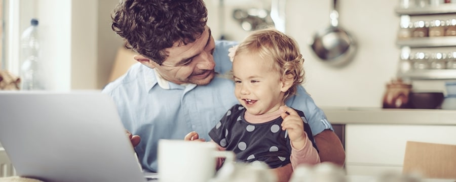 Father working from home and taking care of his daughter