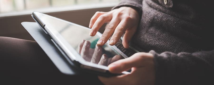 Woman reviewing financial information on iPad.