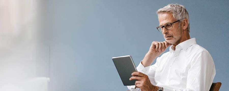 Businessman reviewing market performance on his tablet.