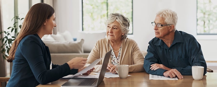 Couple looking at computer and drinking coffee.