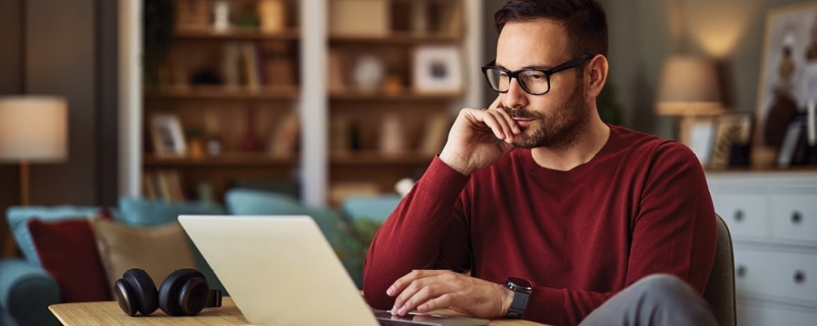 Man reviewing finances on laptop.