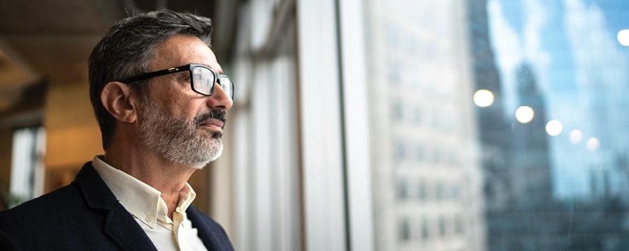 Mature businessman looking out window.