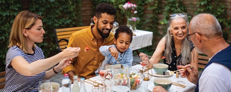 Intergenerational family has dinner together outside