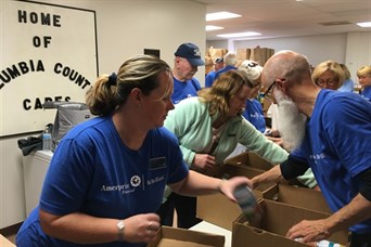 Team members and clients help sort donated food items at the Columbia County Cares Food Pantry.